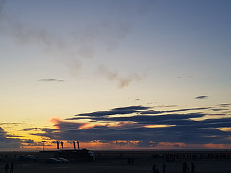 Dramatic Sunset Sky Over Beach With Silhouetted Crowd