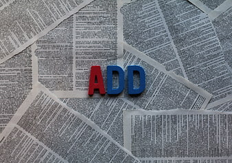 Red and blue foam letters spelling ADD on newspaper background