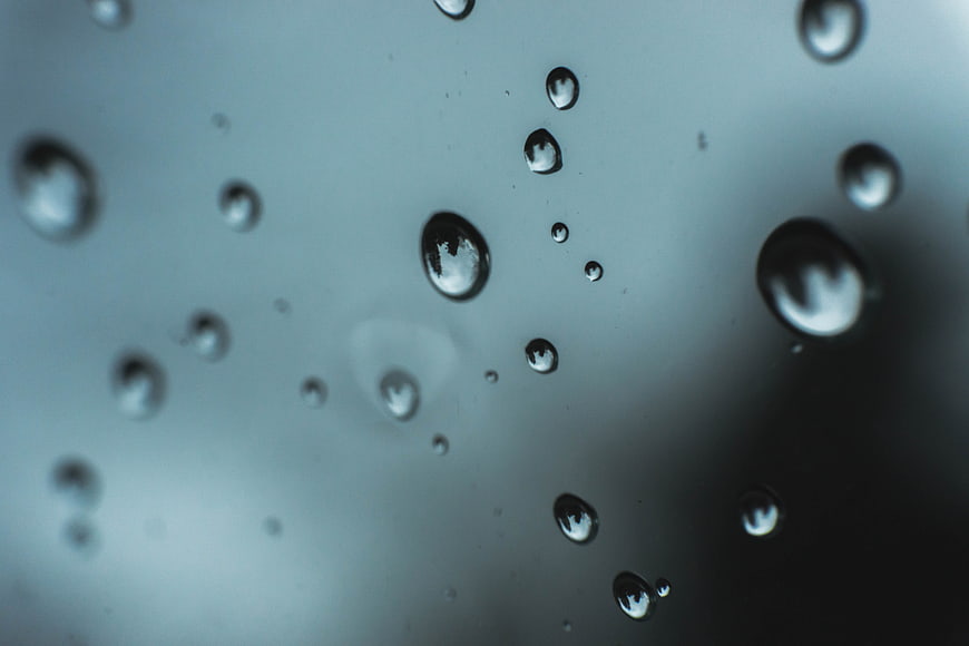 Macro shot of water droplets on a glass window surface