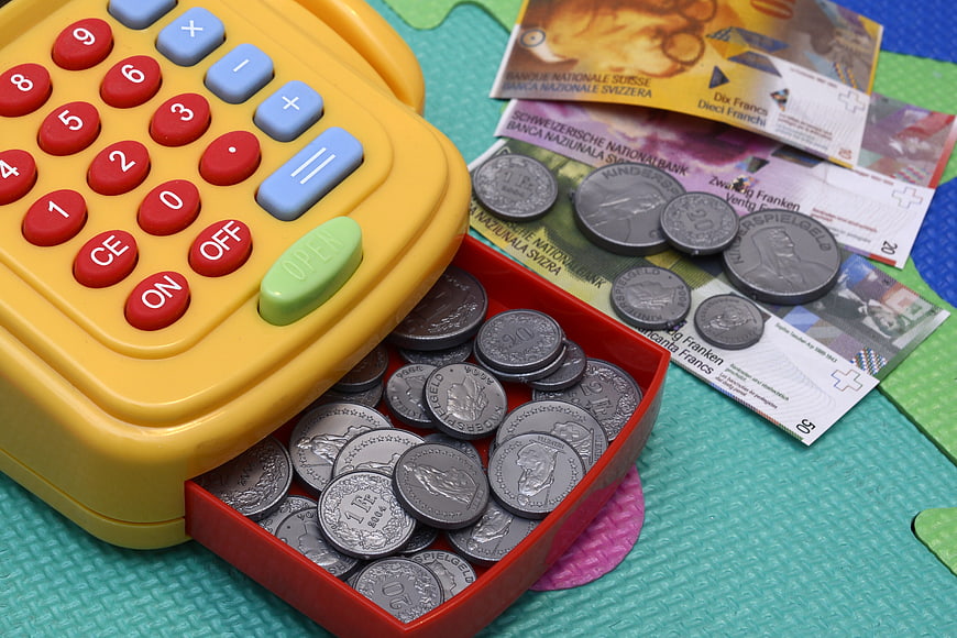 Toy cash register with play money and coins