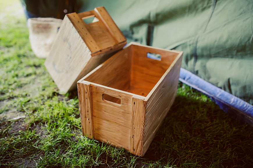 Rustic wooden crates on grass near camping tent