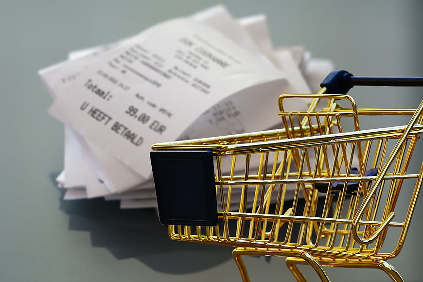 Golden Mini Shopping Cart with Stack of Receipts