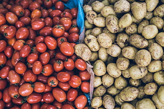 Fresh red tomatoes and raw potatoes at a market