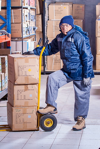 Warehouse worker with hand truck and boxes