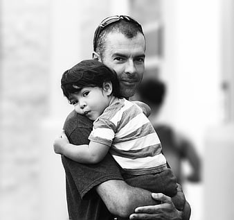 Black and white portrait of father holding young son