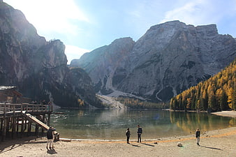 Autumn landscape of Pragser Wildsee lake with mountains and tourists