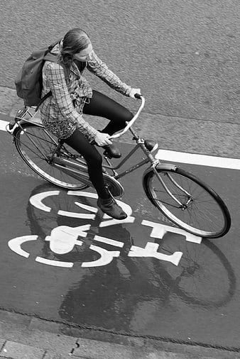 Woman Cycling on Wet Street with Bicycle Symbol