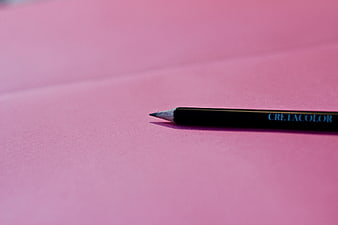 Black pencil on pink paper background
