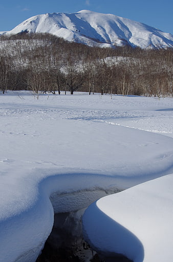 Snowy Stream in Nalychevo Valley with Volcanic Mountain Background