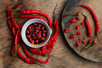 Top View of Red Chili Peppers and Spicy Sauce on Wood