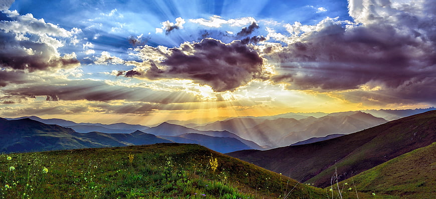 Dramatic Mountain Landscape with Sun Rays and Clouds