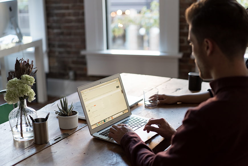 Man working on laptop in modern office workspace