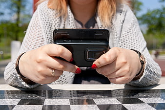 Woman Holding Vintage Slide Phone on Outdoor Table