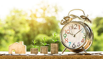 Financial Growth Concept with Coins, House, and Alarm Clock
