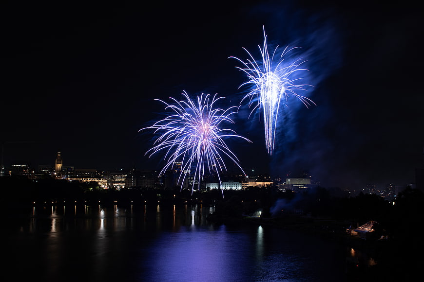 Blue fireworks exploding over city skyline at night