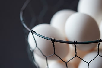 Close-up of white eggs in a wire basket