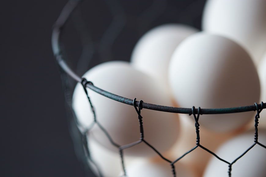 Close-up of white eggs in a wire basket