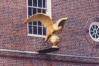 Golden eagle statue on brick building facade