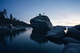 Serene Blue Hour Landscape with Large Rock Formation in Calm Water