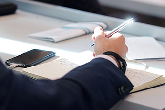 Businessman Writing Notes In Notebook During Conference Meeting