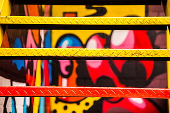 Colorful Graffiti Art Behind Yellow and Red Metal Stairs