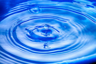 Blue Water Droplet Creating Ripples in Slow Motion