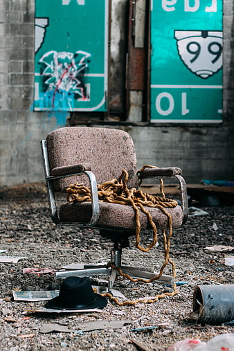 Old office chair with rope and hat in abandoned warehouse