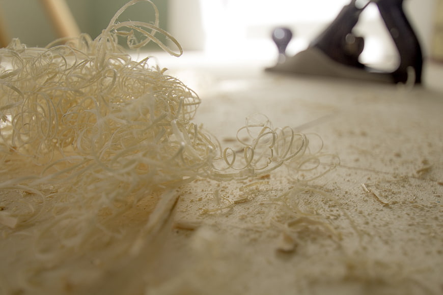 Close-up of curly wood shavings and sawdust on workbench