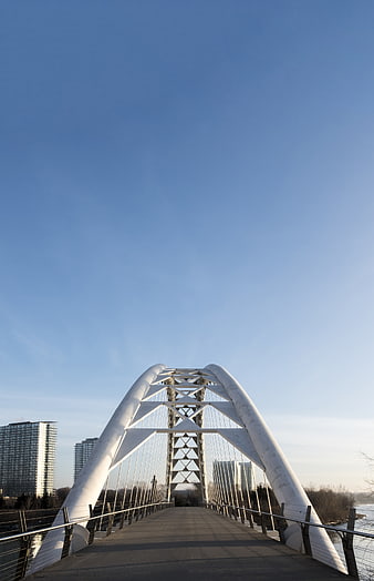 Modern White Arch Bridge with Blue Sky and Cityscape