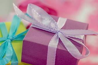Close-up of purple gift box with white ribbon