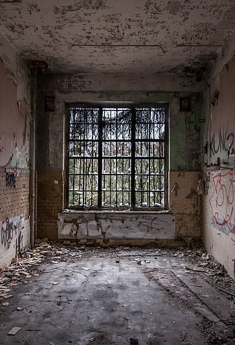 Abandoned Interior Room With Peeling Walls And Barred Window