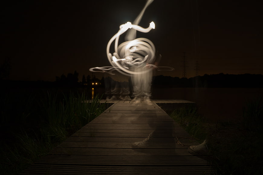 Light painting abstract swirl on wooden pier at night