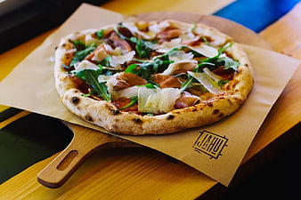 Fresh Pizza with Arugula and Prosciutto on Wooden Board