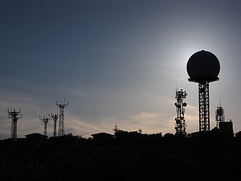 Silhouette of Radar Dome and Communication Towers at Dusk