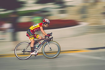 Cyclist in motion blur racing on road