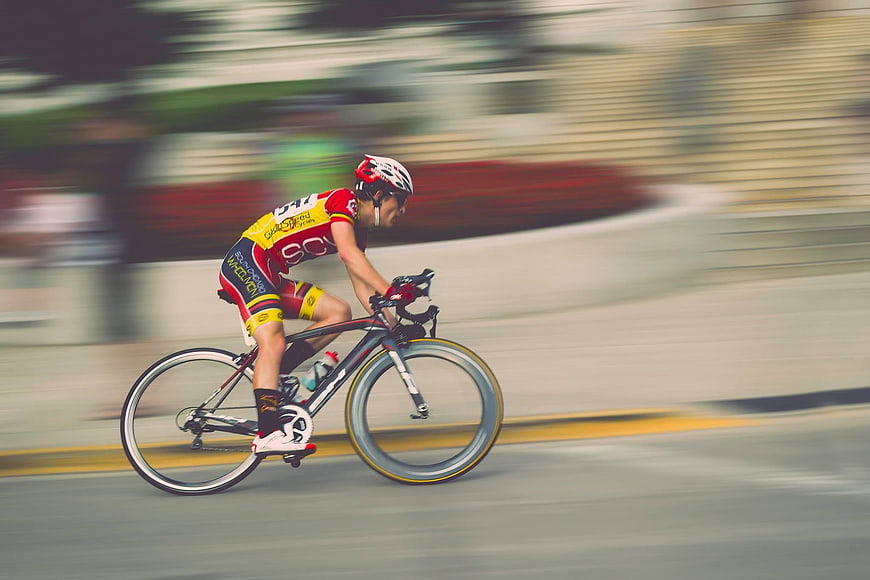 Cyclist in motion blur racing on road