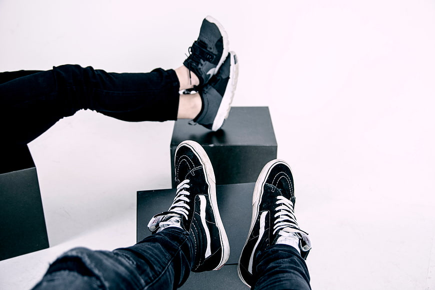 Couple's feet in sneakers on black steps