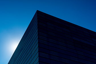 Modern Blue Glass Building Corner Against Clear Sky