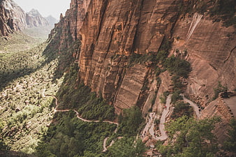 Hikers on winding trail in red rock canyon landscape