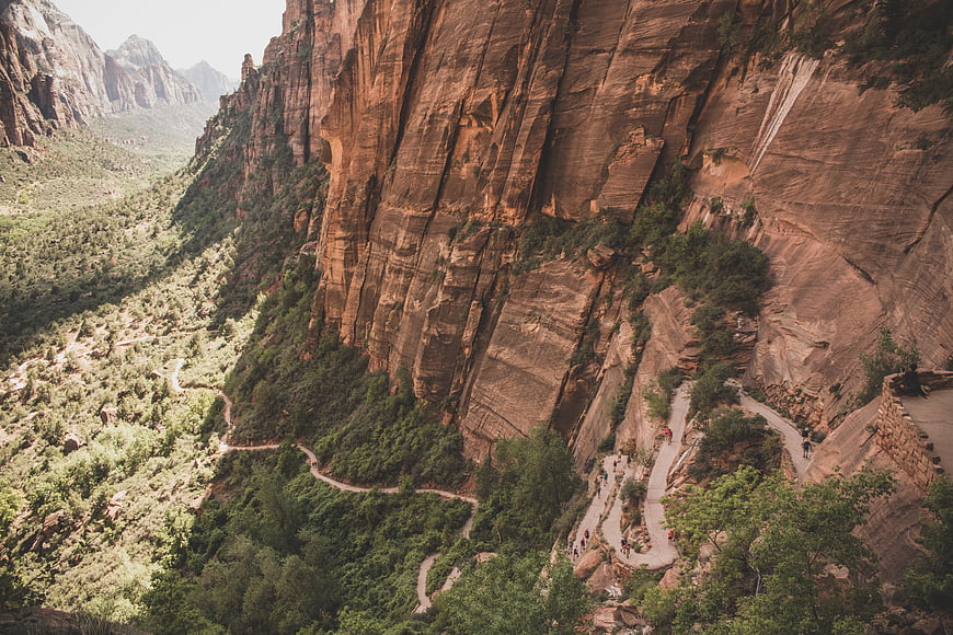 Hikers on winding trail in red rock canyon landscape
