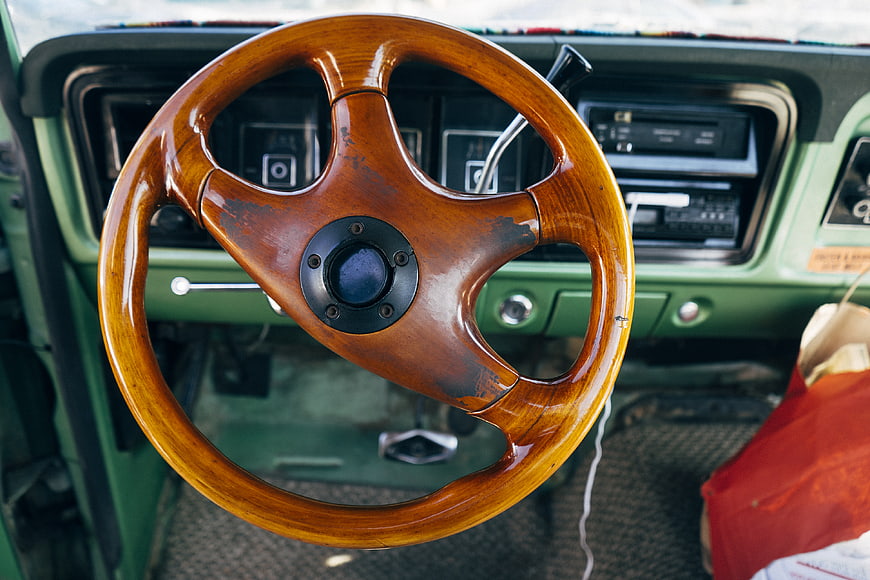 Vintage wooden steering wheel in classic green car interior