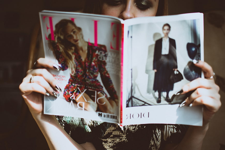 Woman Reading Fashion Magazine with Dior Ad