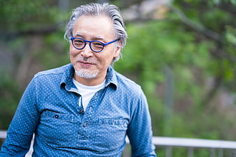 Portrait of a smiling senior man with gray hair and blue glasses