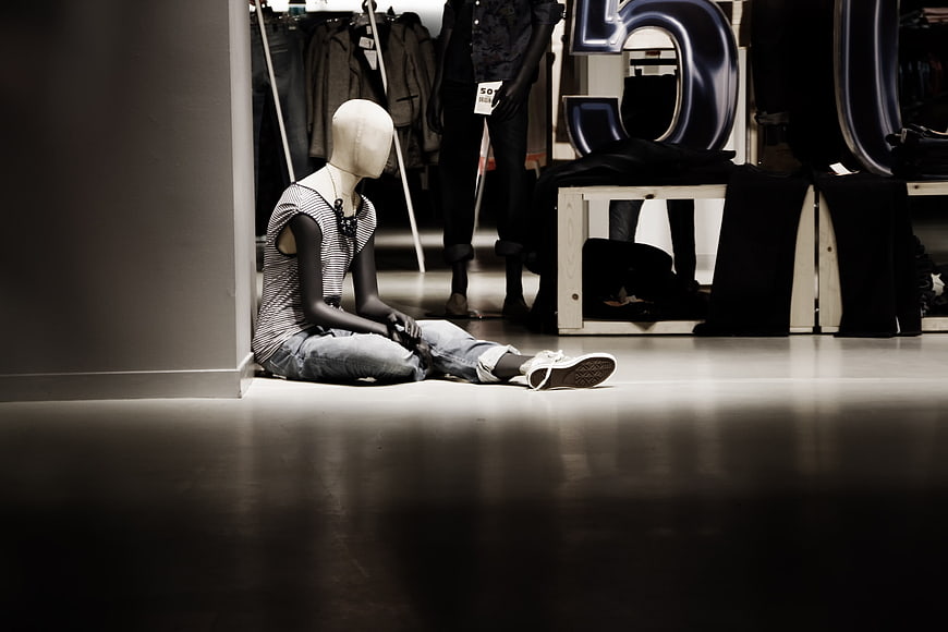 Lonely Mannequin Sitting on Floor in Clothing Store
