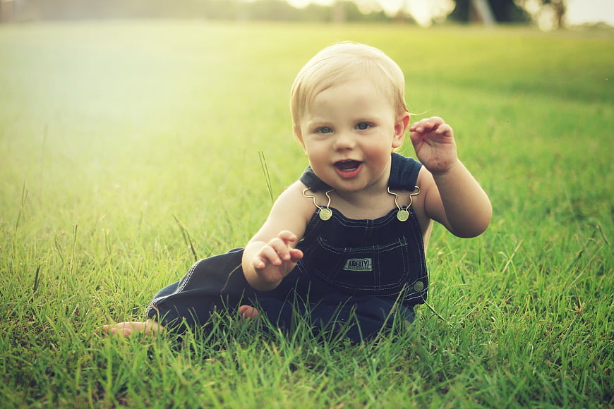 Happy Baby Boy Crawling in Green Grass