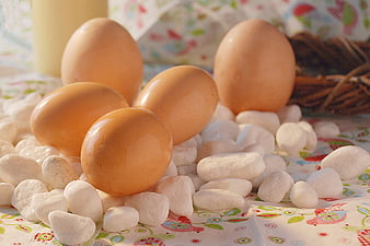 Brown eggs on white stones with Easter tablecloth
