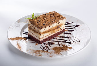 Tiramisu Cake Slice on White Plate with Chocolate Drizzle