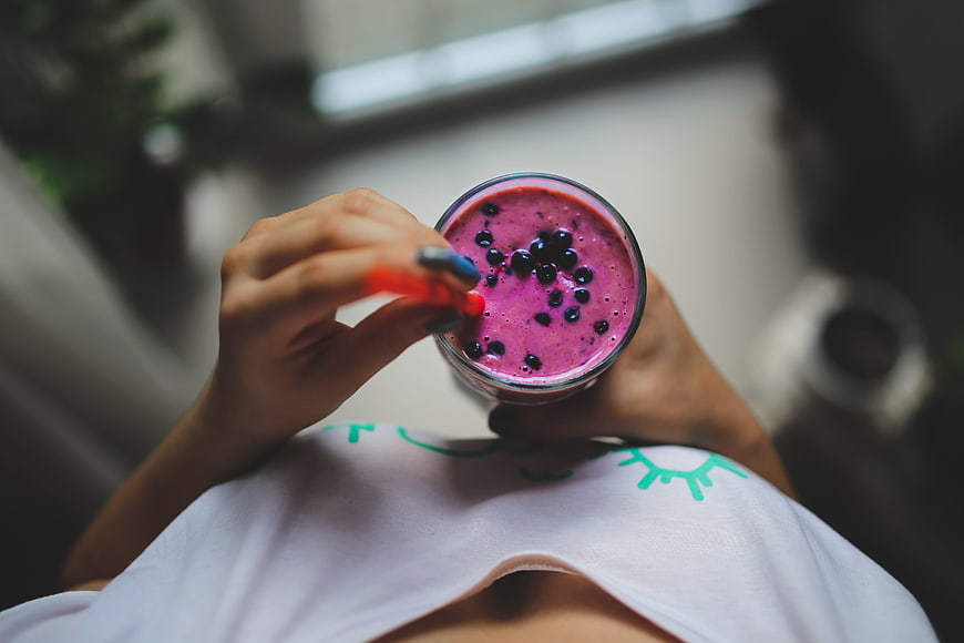 Top View of Woman Holding Blueberry Smoothie