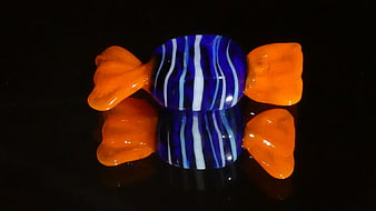 Blue and Orange Glass Candy Sculpture on Black Background