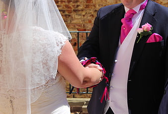 Bride and Groom Tying the Knot with Pink Ribbons